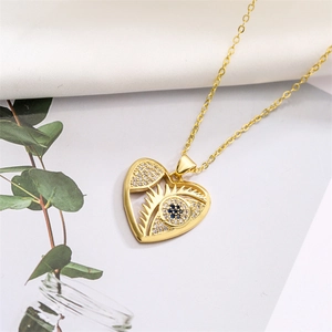 Detail of gold heart pendant necklace featuring evil eye design with blue crystals
