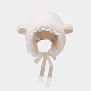 Detail of white plush lamb ear hat with lace trim and soft satin ribbons for warmth