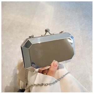 Detail of silver mirrored clutch bag with geometric shell and vintage metal twist lock