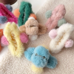 Close-up of assorted colorful plush hair claws with soft faux fur and pom-pom details