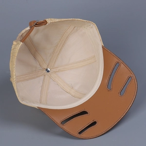 Macro detail of raffia baseball cap with leather brim and adjustable back strap