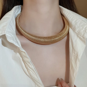 Macro shot of chunky gold textured choker necklace with horizontal spiral patterns