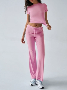 Detail of pink two-piece set featuring short sleeve crop top and drawstring flared pants