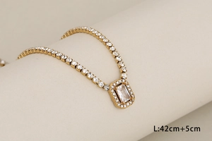 Detail of gold claw chain necklace with rectangular zircon and clear rhinestones