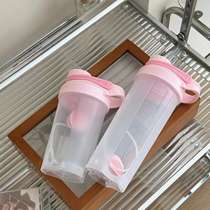 Detail view of pink shaker bottles with protein mixing balls and frosted finish
