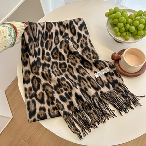 Classic leopard print cashmere scarf with elegant tassels on a white surface