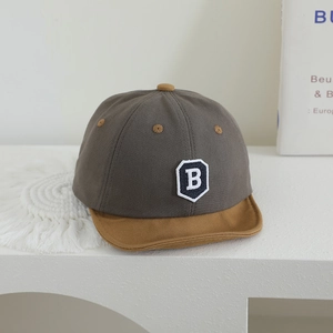 Detailed close-up of gray baby baseball cap with yellow brim and embroidered B patch