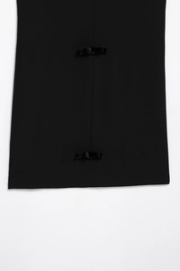 Détails de nœuds en velours noir sur le tissu d'une robe courte texturée