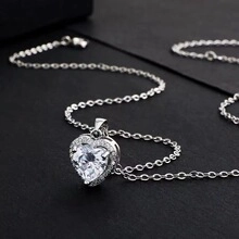 Detailed view of s925 silver heart pendant necklace with shimmering crystals on black background