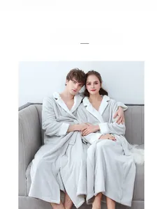 Detail of plush coral fleece bathrobe showing soft grey fabric and white faux fur trim cuffs