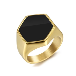 Detail shot of the hexagonal gold-plated signet ring with a smooth black stone inlay