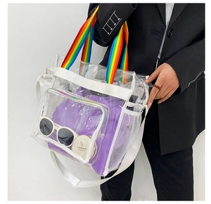 Detail of transparent PVC beach bag featuring rainbow handles and adjustable strap