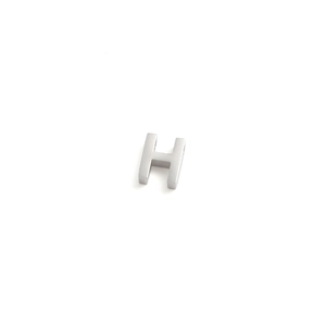 Macro detail of a 10mm polished silver stainless steel letter H charm for DIY necklaces
