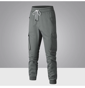 Dettaglio dei pantaloni cargo grigi con vita elastica, coulisse bianca e tasche laterali
