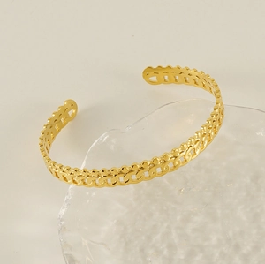 Détail du bracelet en acier plaqué or 18 carats avec motif de perles et chaîne cubaine