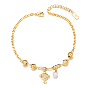 Golden multi-layer bracelet with Saturn charm, white pearl, and zircon heart pendant