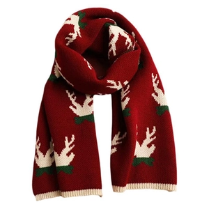 Red knit Christmas scarf with white reindeer pattern and green accents on white background