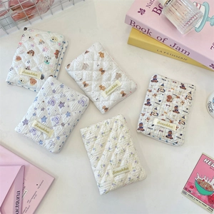 Close-up of quilted fabric passport holders with cute cartoon prints and brand tag