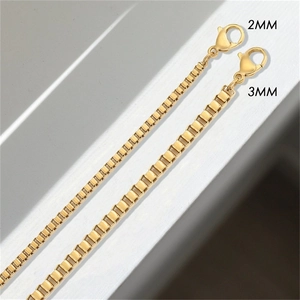 Detail of 2mm and 3mm gold box chains in polished stainless steel with lobster clasps
