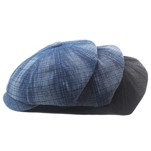 Detailed view of three newsboy caps in light blue, dark blue and black striped denim fabric