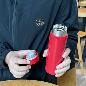 Mini red 304 stainless steel vacuum insulated pocket cup being held with lid open