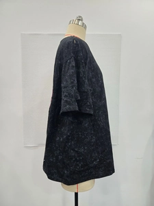 Detail view of washed black oversized T-shirt with drop shoulders and vintage acid wash texture