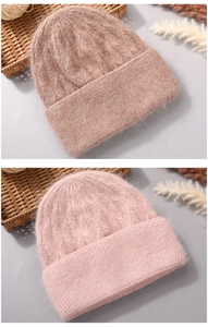 Detail of cable knit pattern and soft angora wool texture on two pastel pink winter hats
