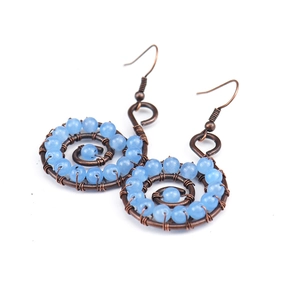Detail of handmade bronze wire wrapped yoga earrings with blue natural stone beads