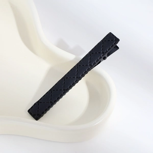 Minimalist black PU leather hair clip with elegant quilted stitching and metal base