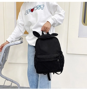 Detail of cute black bunny ears backpack with large capacity shown in hand