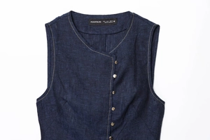 Close-up of deep blue fabric texture with silver buttons and contrast stitching details