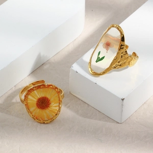 Macro shot of 18K gold plated ring with inlaid dried orange flowers and resin detail