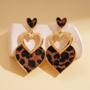 Retro leopard print tiered heart earrings with golden metal accents on stone display