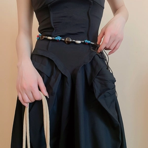 Detail van etnische kralen heupketting met blauwe kralen en schelpen op een jurk