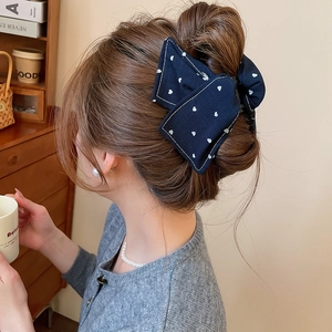 Pince à cheveux noeud bleu foncé en tissu avec motifs de coeur sur chignon élégant