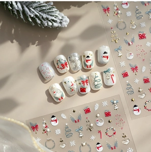 Detail of 3D gold embossed Christmas nail stickers featuring trees, bells and stars