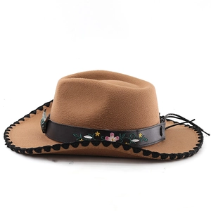 Close-up of brown western cowboy hat with floral embroidery and turquoise detail