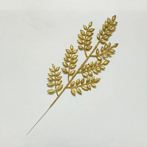 Dettaglio di un ramo di pianta artificiale dorato con brillantini per il Natale