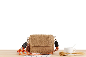 Handmade woven beach bag featuring a colorful geometric strap and brown leather tassels