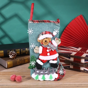 Detail of Christmas stocking with 3D plush bear and red buffalo plaid linen texture