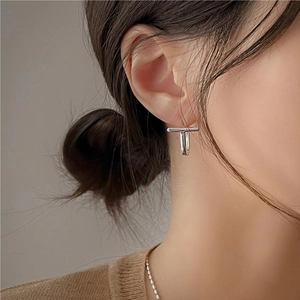 Elegant 925 sterling silver T-shaped stud earrings worn by model for a minimalist look