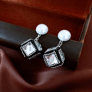 Macro detail of vintage square pearl earrings with zirconia crystal inlay and silver finish