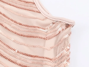 Détail du tissu en maille champagne doré avec sequins ondulés et finitions de couture fines