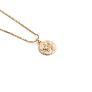 Detailed view of a gold pendant with a star shape made of small diamonds on a box chain