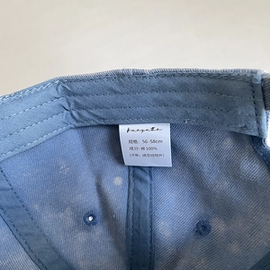 Detail view of cotton baseball cap interior showing 100% cotton label and stitching