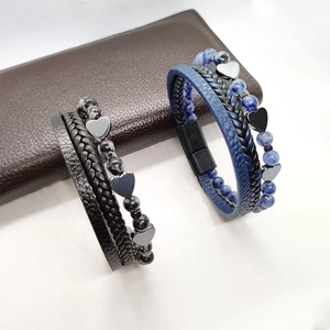 Dettaglio di bracciali multistrato in pelle con perline a cuore e chiusura magnetica
