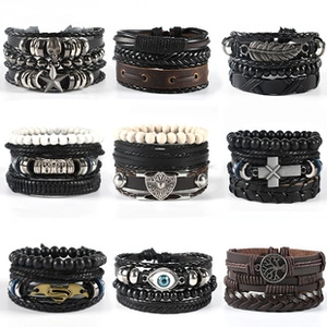 Detail of multi-layer woven leather bracelets featuring skull, cross, and retro metal charms
