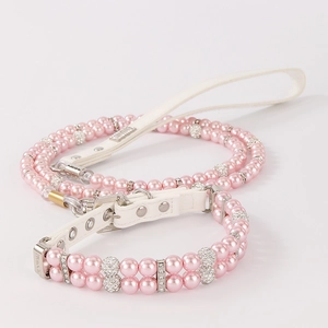 Detail of luxury pink pearl pet collar with rhinestone accents and white leather strap
