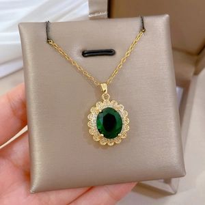 Dettaglio della collana d'oro vintage con pietra ovale verde smeraldo e alone di zirconi