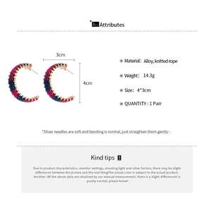 Detail view of colorful knitted C-shaped hoop earrings with size and material specifications
